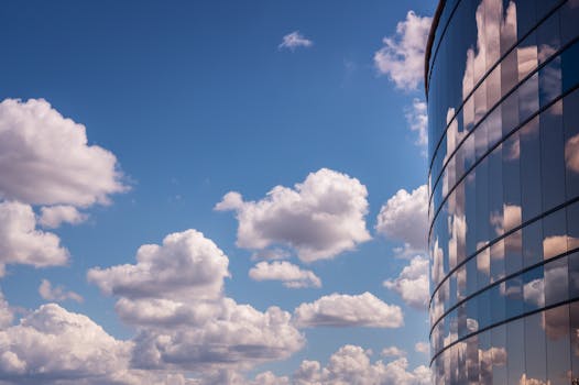 晴朗的蓝天下，现代建筑的玻璃立面映照着云彩