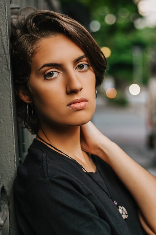 Woman Wearing Black Top Leaning On Wall