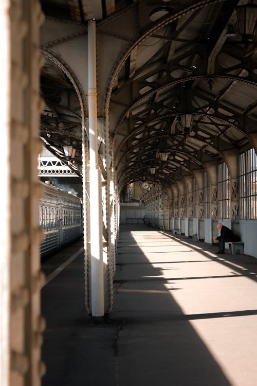 A person is sitting on a bench in a train station