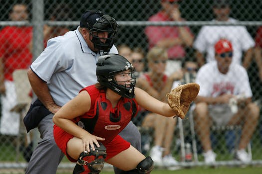 Female catcher in action during a baseball game, showcasing focus and athleticism.