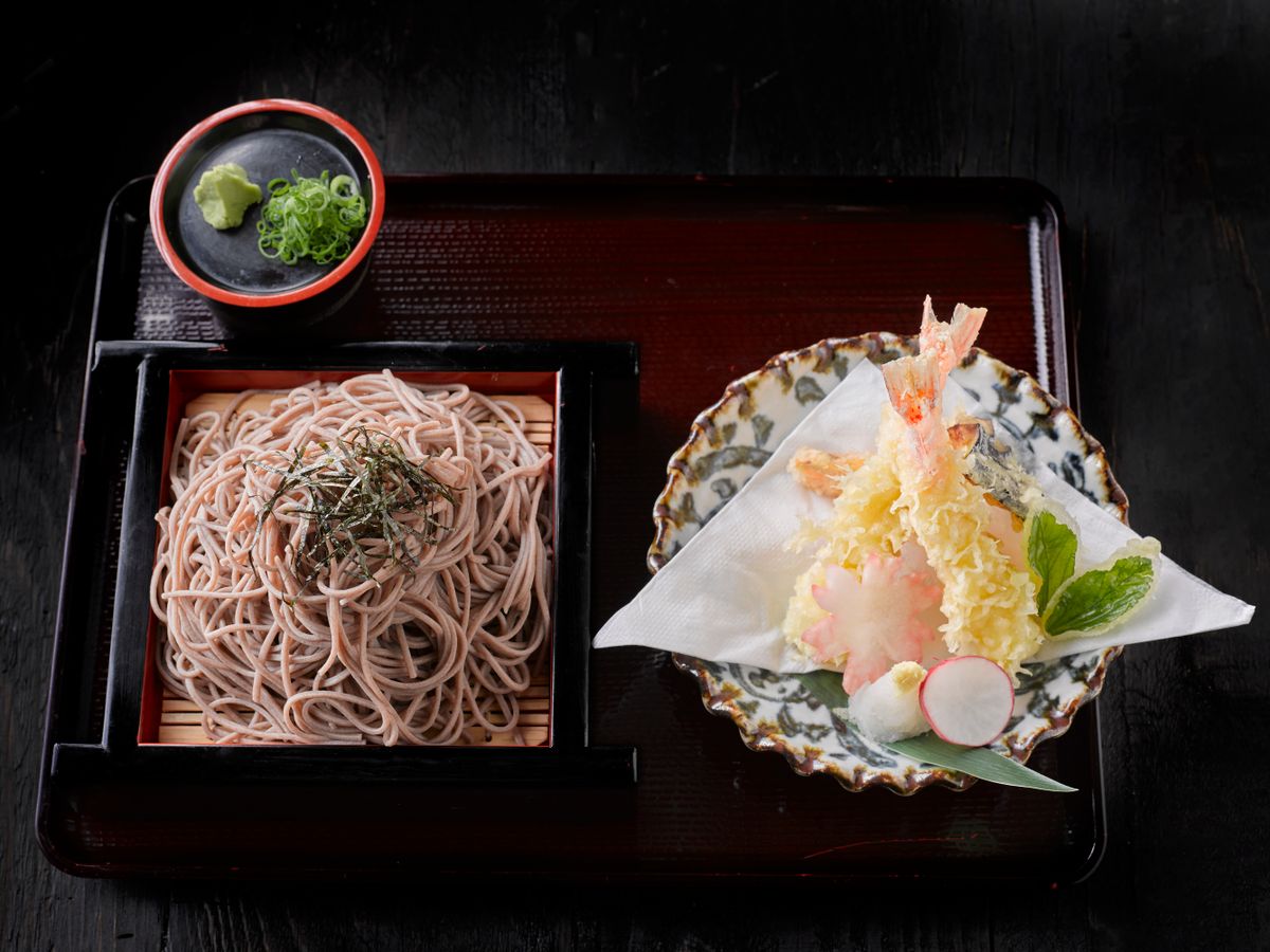 Cold buckwheat soba on a bamboo tray with nori, dipping condiments and shrimp and vegetable tempura