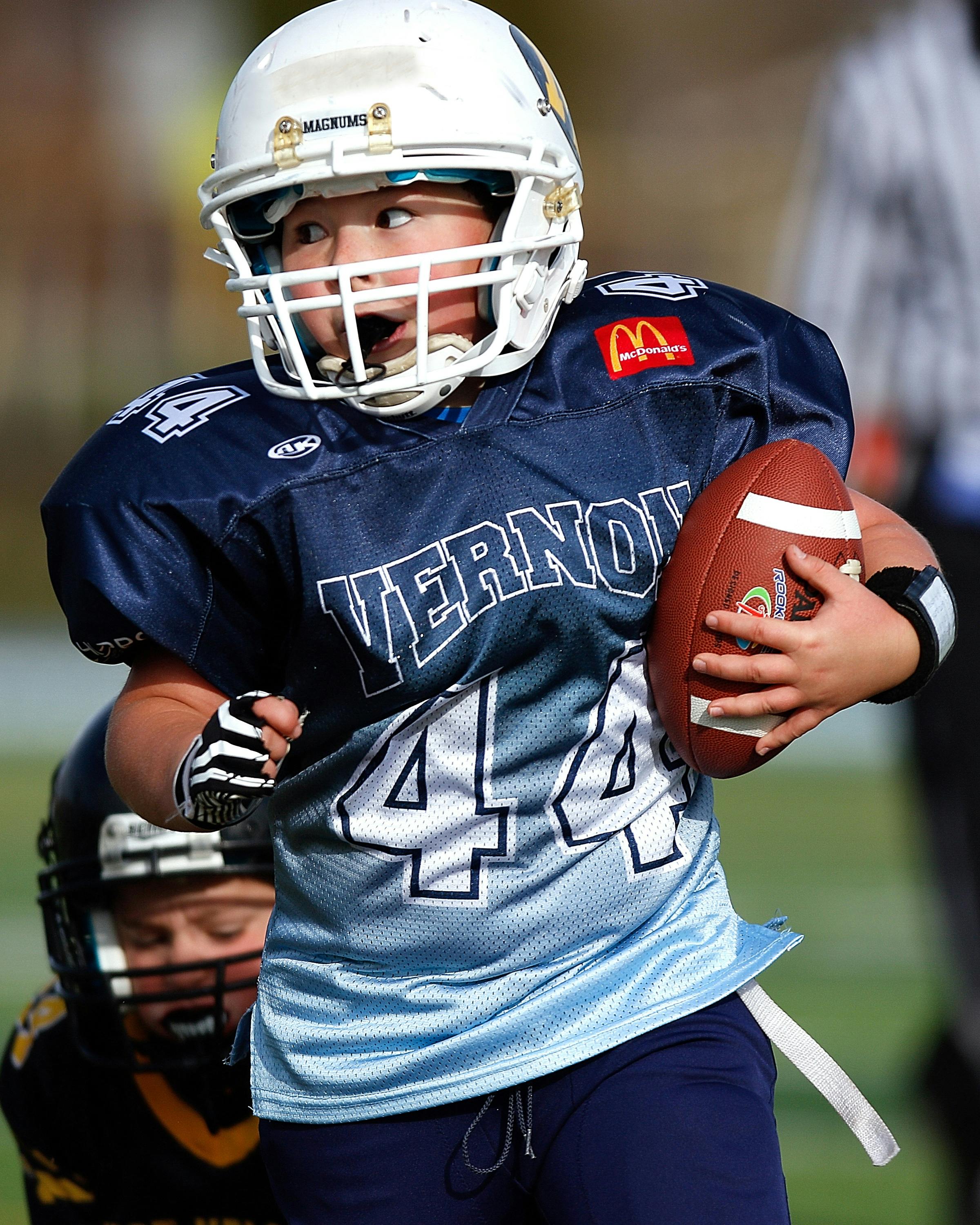 Boy Wearing Football Gear While Holding Football · Free Stock Photo