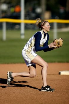 Dynamic image of a woman baseball player ready to catch during a game outdoors.