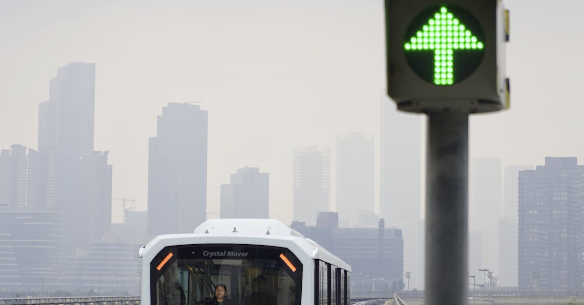 Photo by Jansen Liu A modern train travels on an elevated track in Macau with a green arrow sign indicating direction.