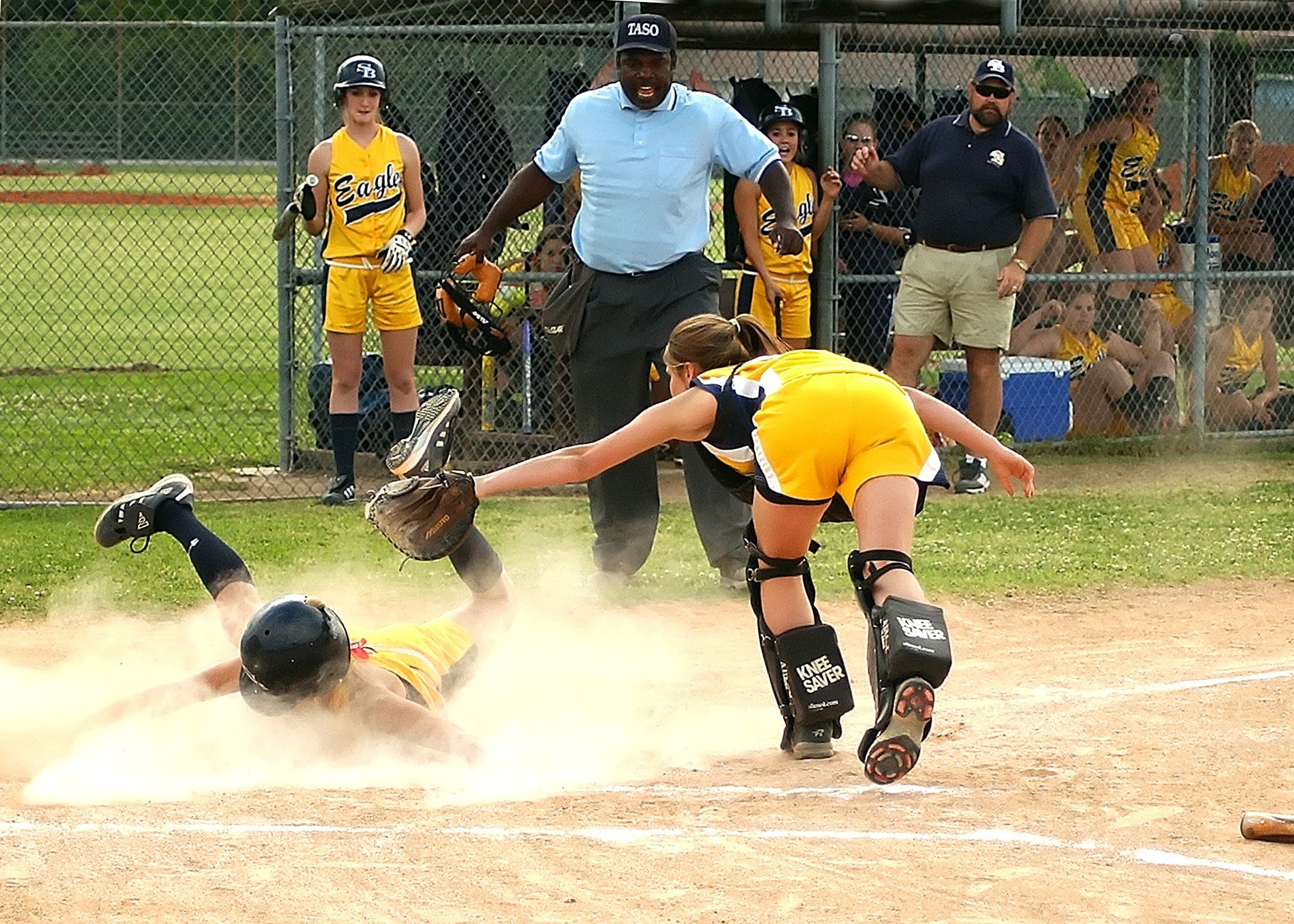 Youth softball player sliding into home plate