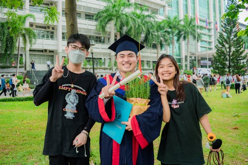 Three people in graduation gowns pose for a photo