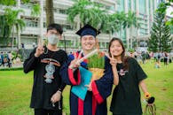 Happy Man Posing with Friends After Graduation