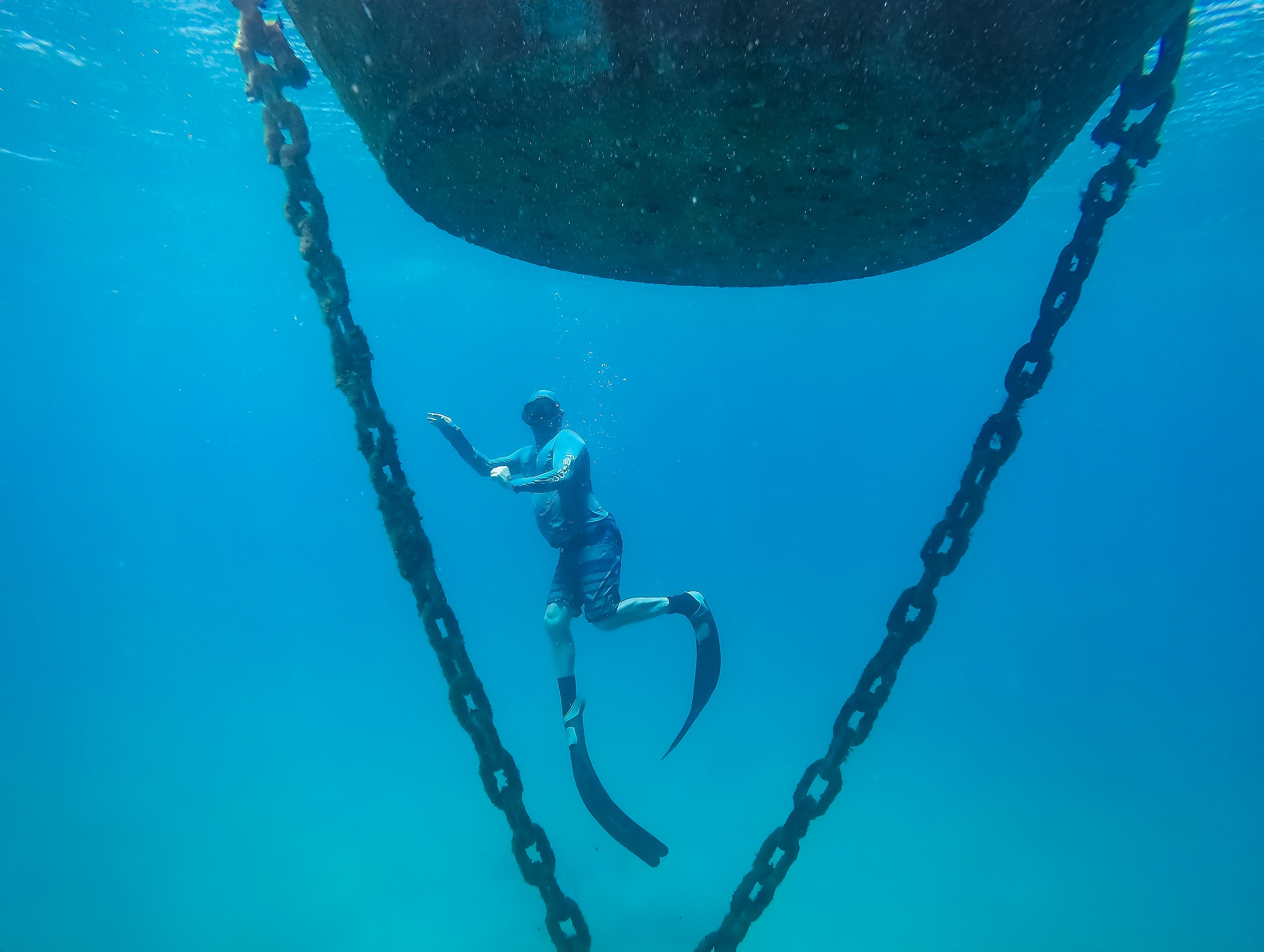 Diver explores the underwater world among chains near Pernambuco, Brazil.