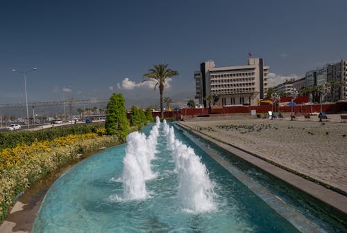 A fountain in front of a building with water fountains