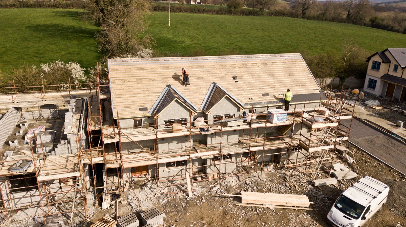 Aerial view of a building under construction on a green site.