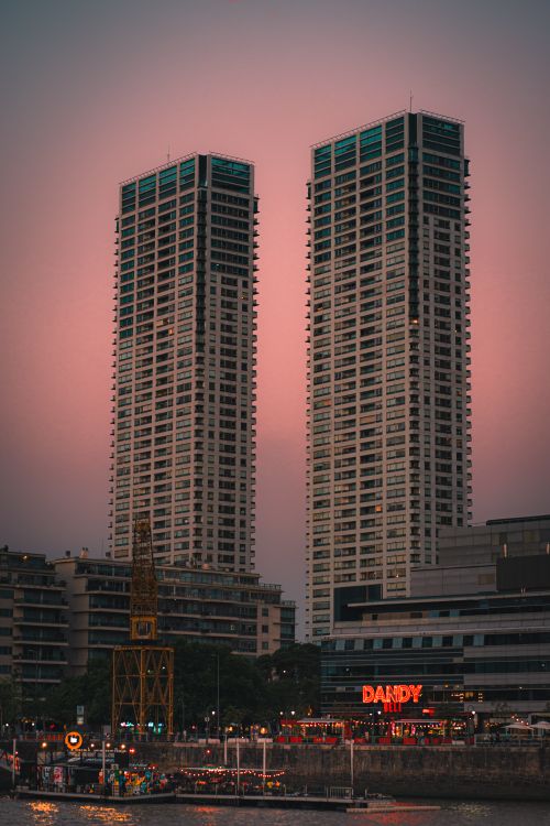 Free The modern skyline of Buenos Aires featuring the iconic Torres del Yacht at sunset. Stock Photo