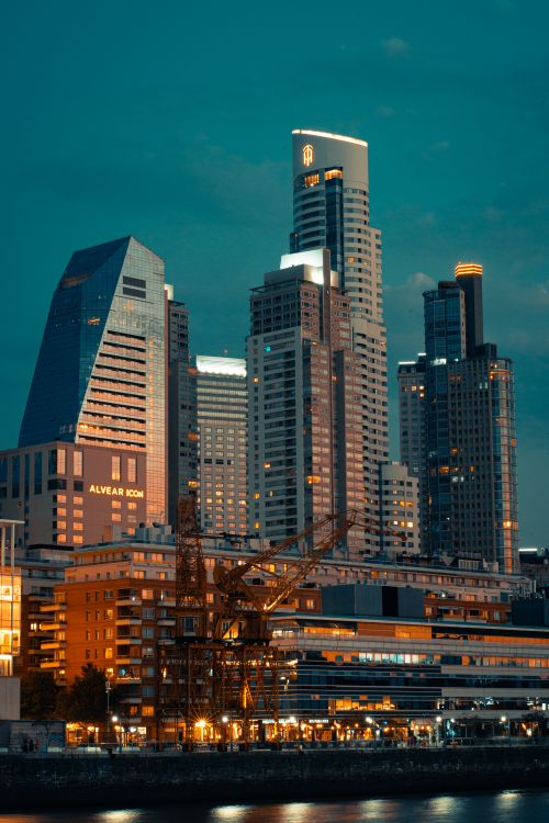 Free A stunning evening view of modern skyscrapers reflecting on the river. Stock Photo