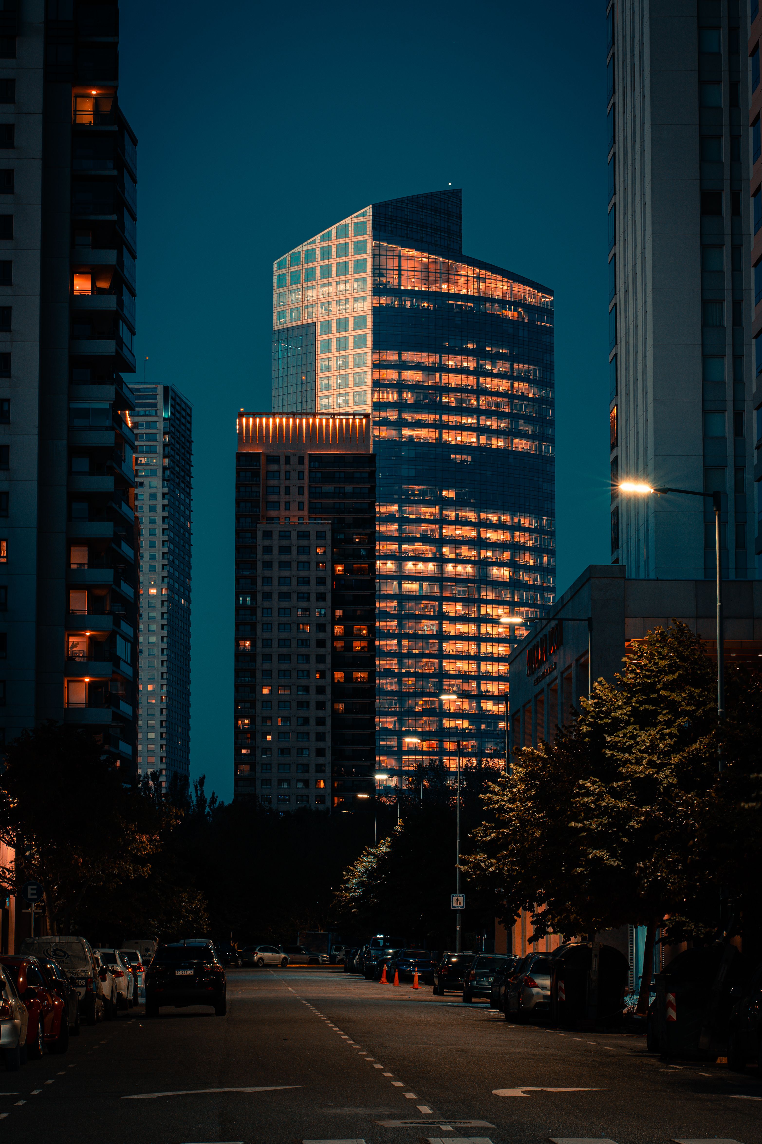 A city street at night with tall buildings · Free Stock Photo