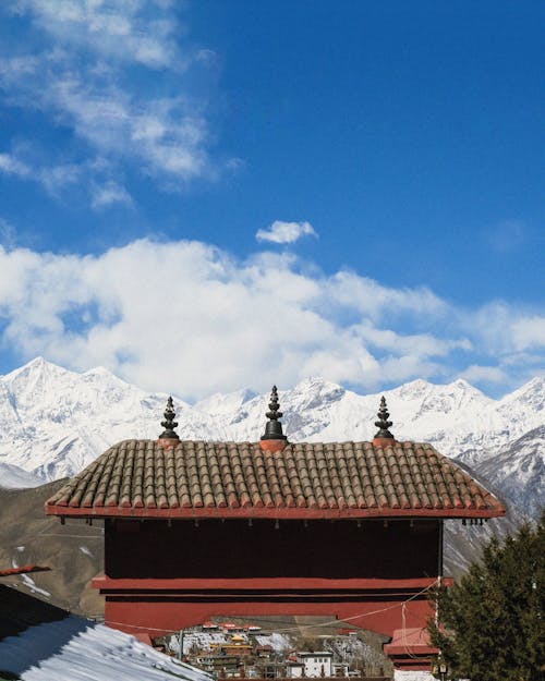 A red roof with snow capped mountains in the background