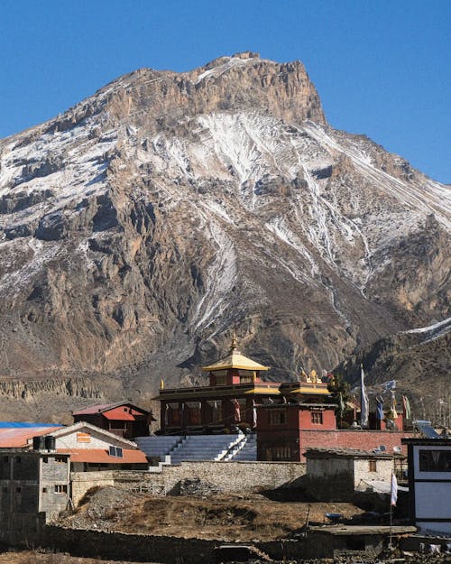 A mountain with a small building in front of it