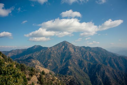 Free Captivating view of a rugged mountain range under a clear blue sky with clouds. Stock Photo