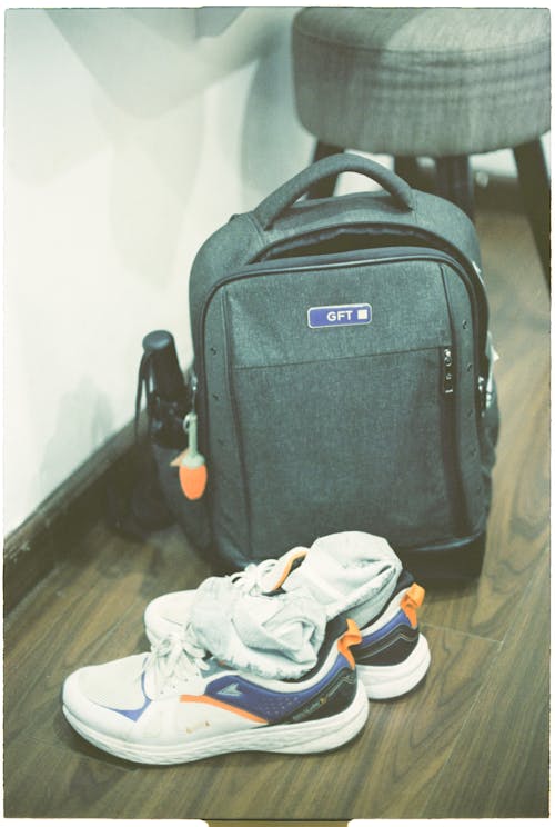 A backpack and shoes on a wooden floor