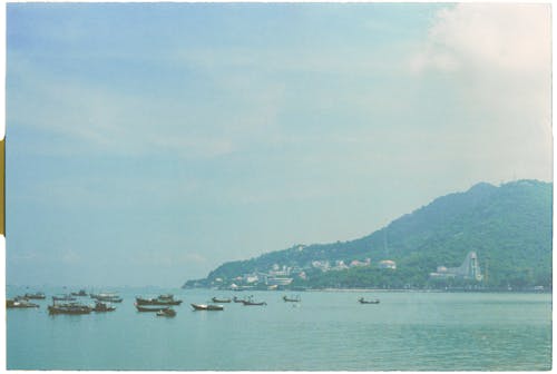 A photo of boats in the water near a mountain