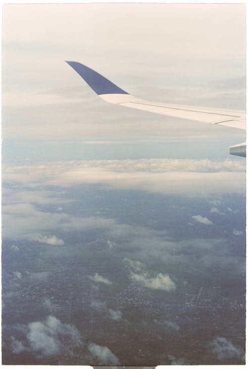 A view of the wing of an airplane flying over a city