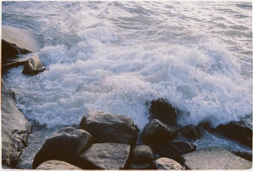 Free Dynamic capture of ocean waves crashing against rocks, creating a foamy seascape. Stock Photo
