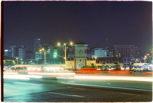 Night view of the iconic Ben Thanh Market with light trails in Ho Chi Minh City, Vietnam.