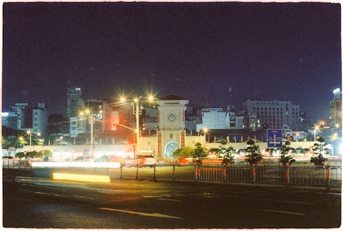 A city street at night with cars and buildings