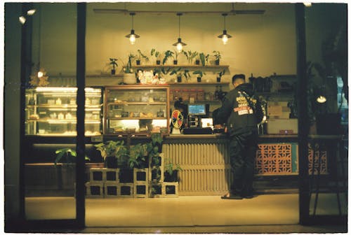 A man standing at a counter in a coffee shop