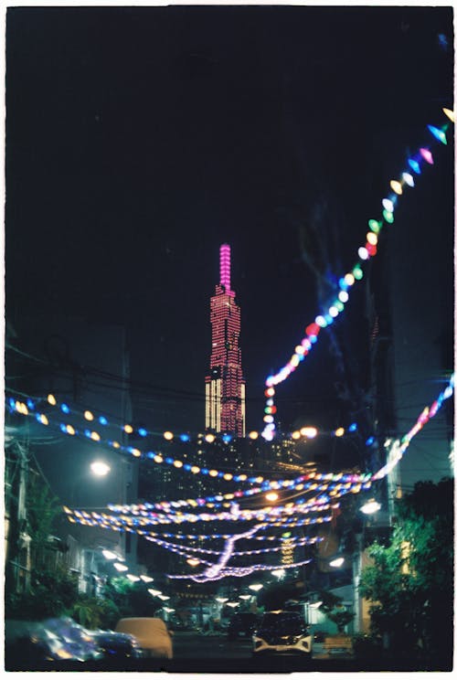 A photo of a city street with lights and a tower