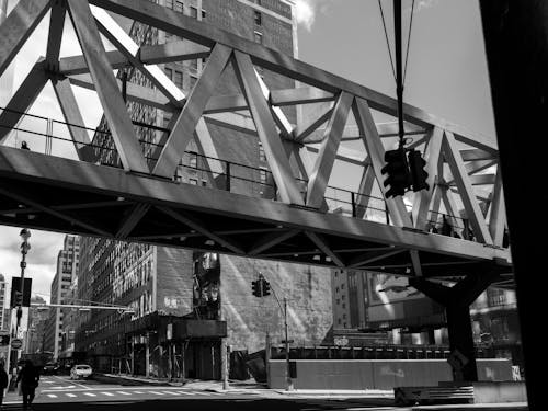 A black and white photo of a bridge over a street