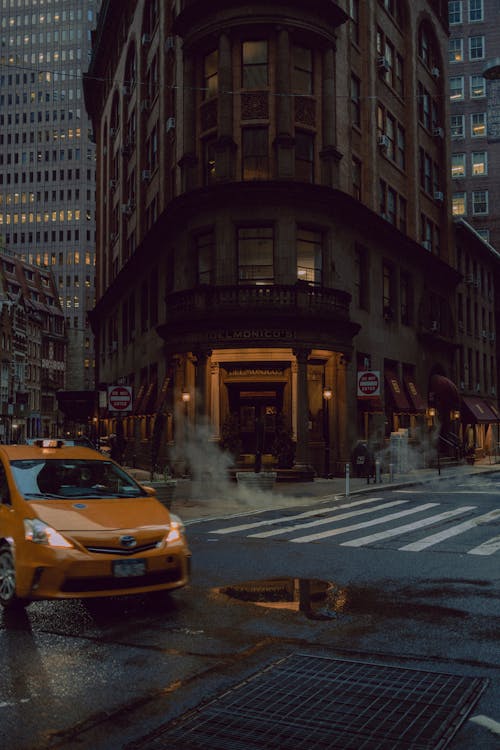 A taxi cab is parked in front of a building