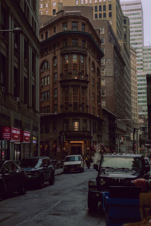 Free A historic building on a bustling street in New York City with parked cars and urban architecture. Stock Photo