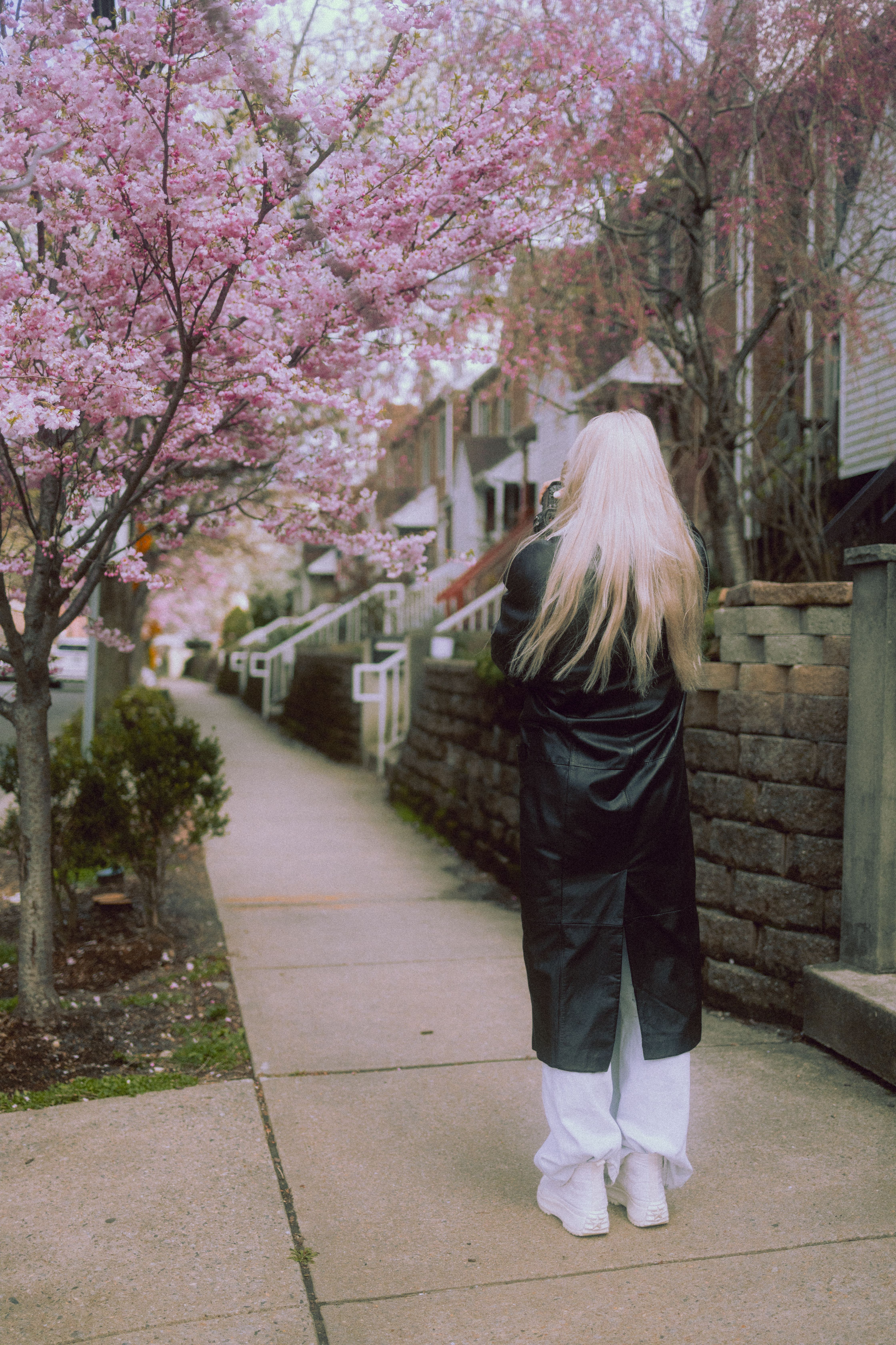 Back View of a Woman Standing on a Sidewalk · Free Stock Photo