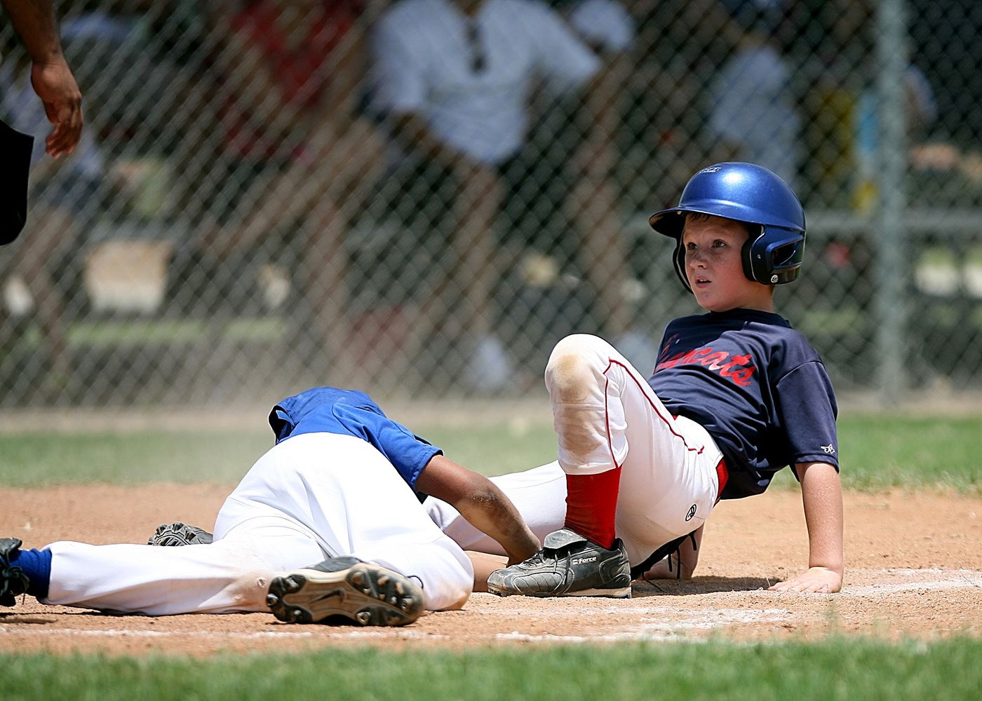Young runner sliding in as the fielder applies the tag