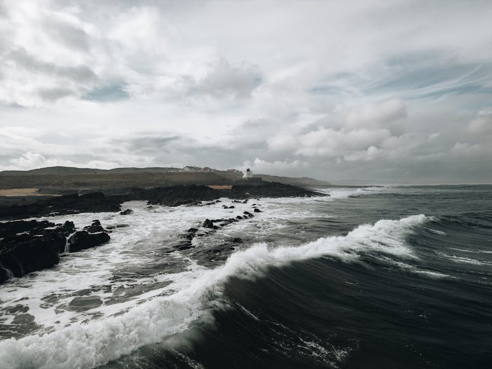 A photo of the ocean with waves crashing on the rocks