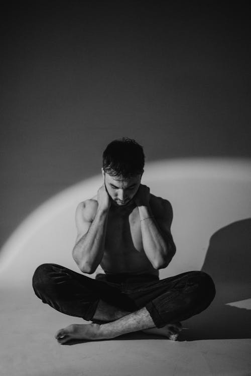 Topless Man Sitting in Black and White