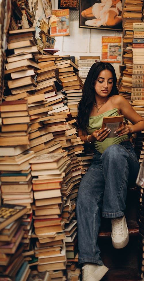 A woman sitting on a pile of books