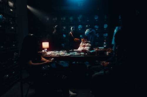 A group of people sitting around a table in a dark room