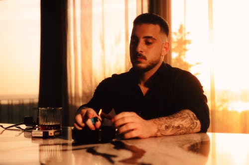 Man Sitting with Lighter by Table