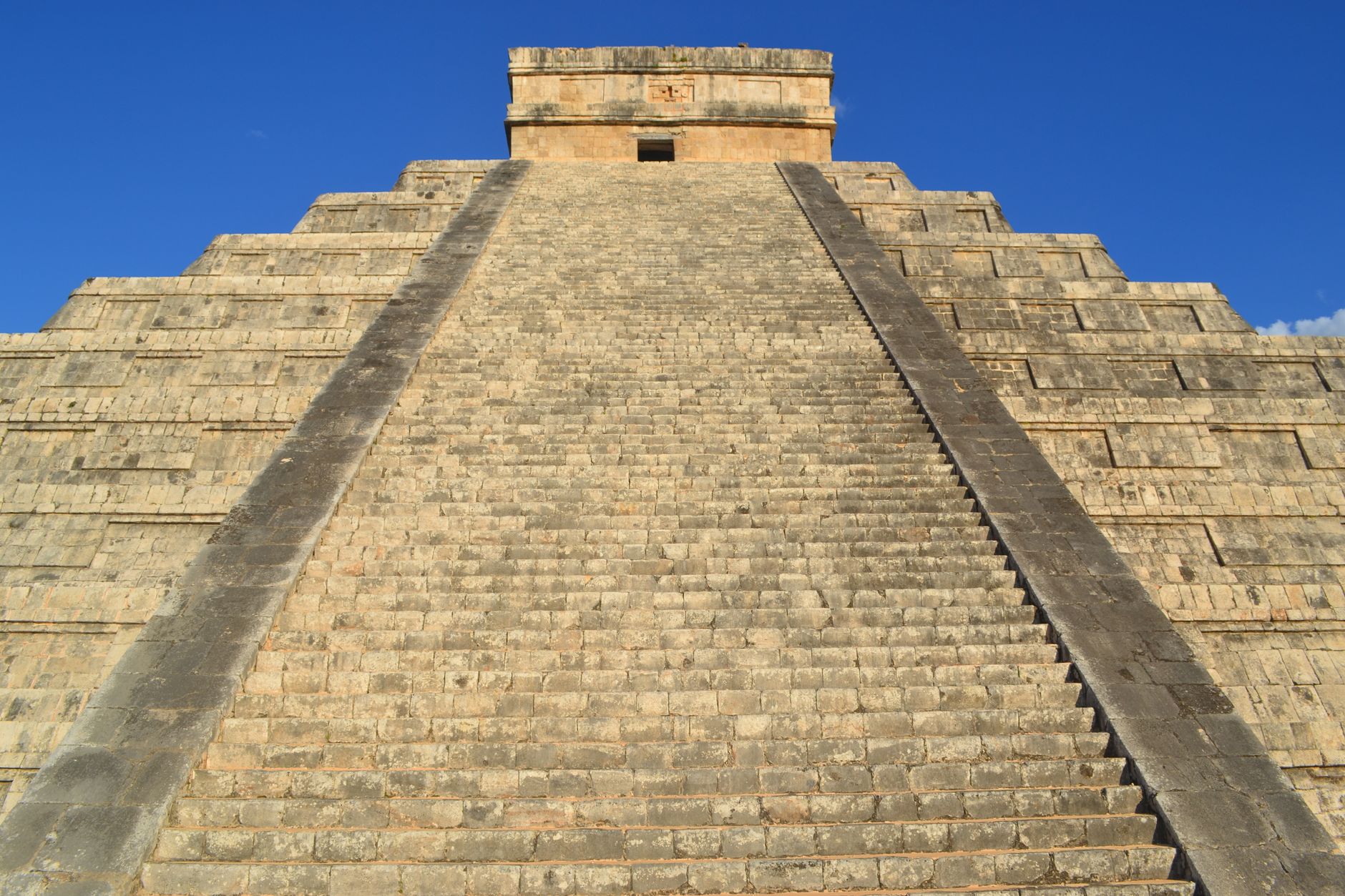 Stunning view of El Castillo pyramid at Chichén Itzá against a clear blue sky.