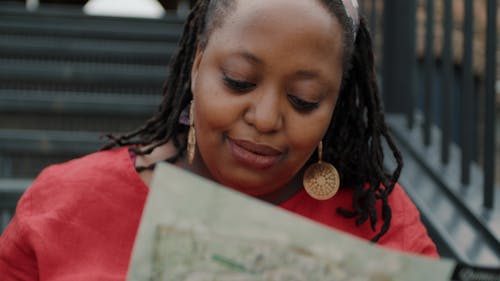 A woman with dreadlocks is looking at a map
