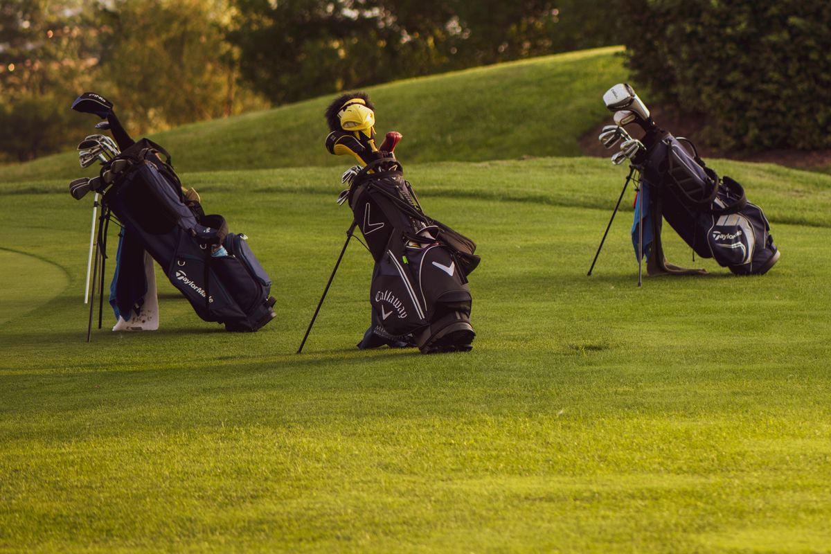 Golf bags with clubs on the course