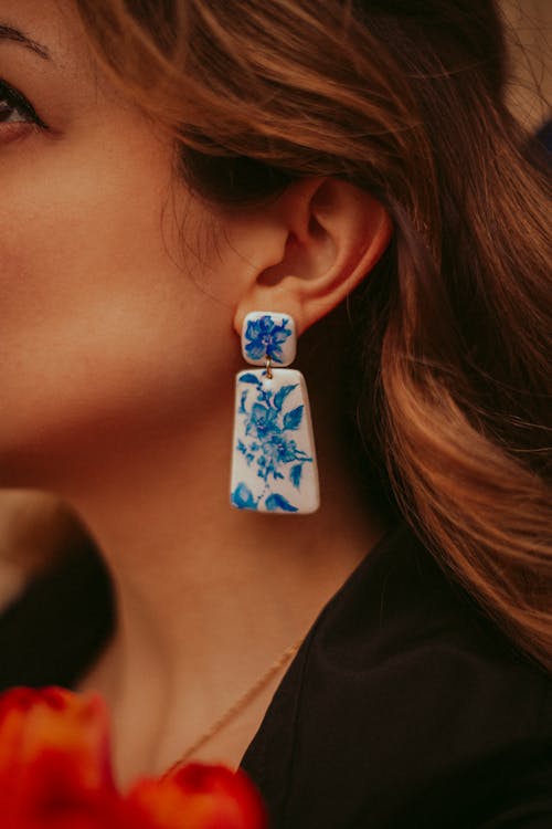 A woman wearing blue and white earrings