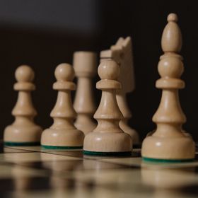 Wooden game pieces set up on a folding board — photo by Matthew Twin on Pexels