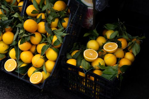 Free Freshly harvested oranges in crates with green leaves at a market in Rome, Italy. Stock Photo