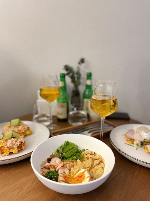 Free A table with two bowls of food and two glasses of wine Stock Photo