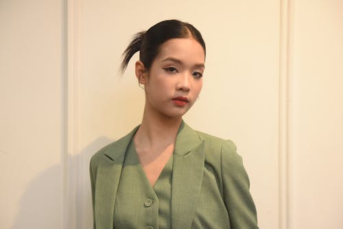 A woman in a green suit and black shirt