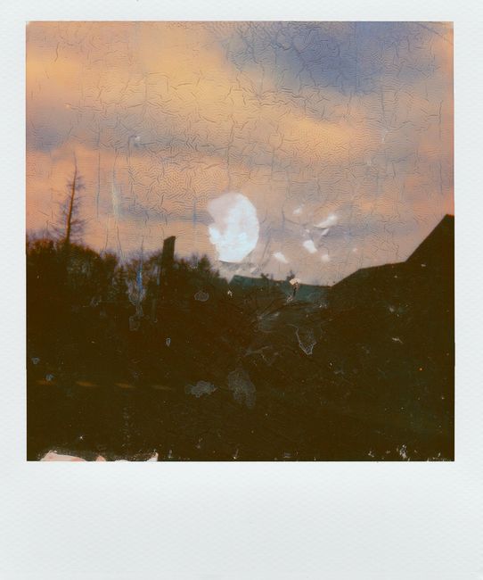 Rustic sunset landscape captured with vintage Polaroid showing silhouette scenery.
