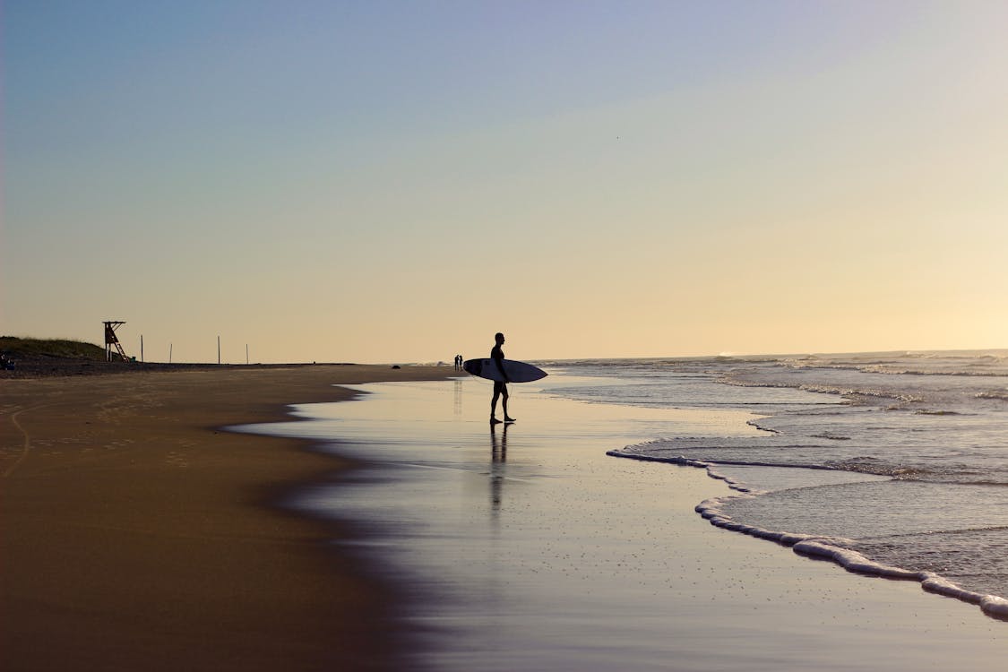 Free Person Holding Surfboard On Shore Stock Photo