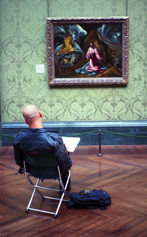 Man Sitting While Reading Book