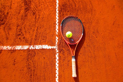 Tennis Ball on Tennis Racket on Floor